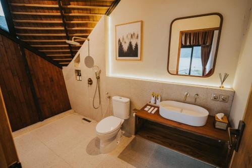 a bathroom with a toilet and a sink and a mirror at Skylake Villa in Kubupenlokan