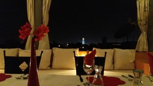 a table with a white table cloth and a table with wine glasses at Dar Andamaure in Marrakech