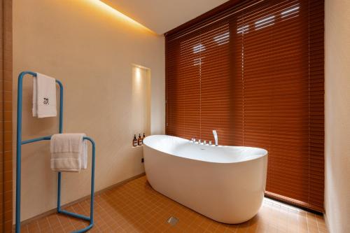 a bath tub in a bathroom with a large window at The Cut Hotel in Medellín