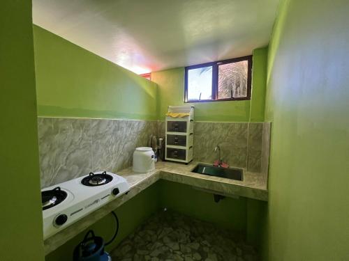 a small kitchen with a sink and a window at Jaliha Homestay in San Isidro