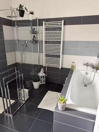 a bathroom with a tub and black and white tiles at Apartmán Mirka in Nový Šaldorf