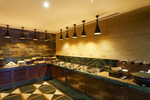 a restaurant kitchen with a counter with food at Ganga Lahari by Leisure Hotels in Haridwār