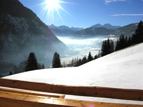 a view of a snow covered mountain with the sun at Chalet Schröckgut in Bad Hofgastein