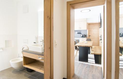 a bathroom with a sink and a kitchen with a counter at Alberts Heimatglück in Nauders