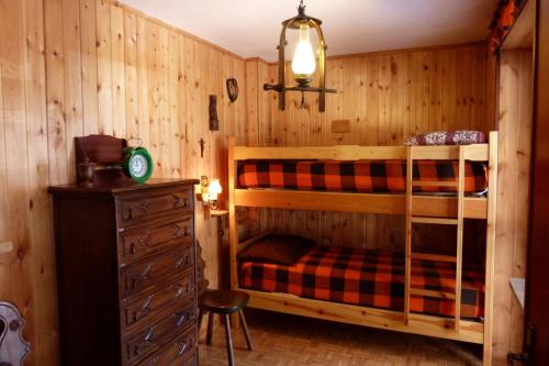 1 Schlafzimmer mit 2 Etagenbetten und einer Kommode in der Unterkunft House Driade by Holiday World in Sauze dʼOulx