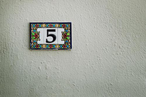 a clock on a wall with the number six at Nereids Apartments in Sitia
