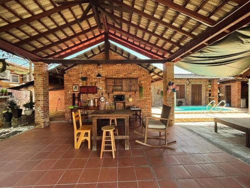 a patio with a wooden roof with a table and chairs at Lelangit Inn in Port Dickson