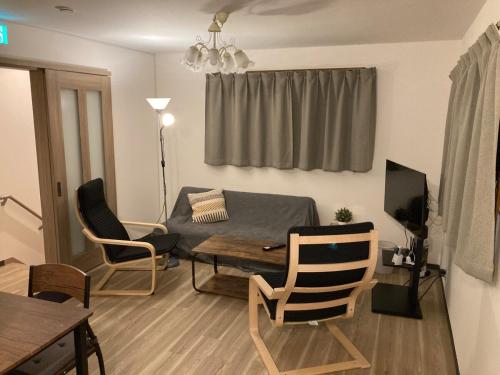 a living room with a couch and a table at Osaka Convenient Location Entire Private Second Floor in Hirakata
