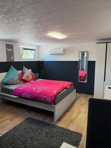a bedroom with a large bed with a red comforter at Apartment im Heidchen in Knüllwald