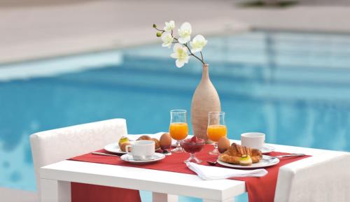 a table with a tray of breakfast foods and orange juice at Orka Lotus Beach in Marmaris
