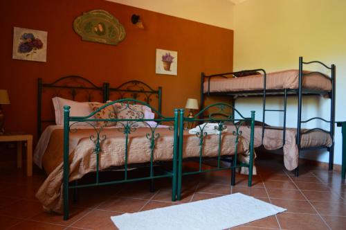 2 Etagenbetten in einem Zimmer mit orangefarbenen Wänden in der Unterkunft B&B Antico Frantoio in Sambuca di Sicilia