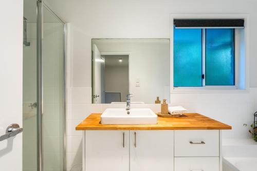a bathroom with a sink and a shower at Treetops Sunrise Beach in Byron Bay