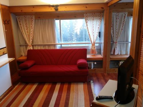 a red couch in a living room with a window at Appartamento Artuik in Marilleva