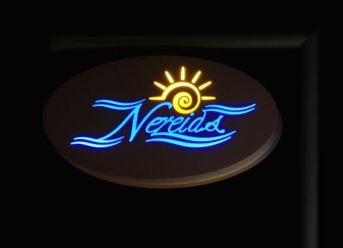 a neon sign for a neptunia restaurant at Nereids Apartments in Sitia
