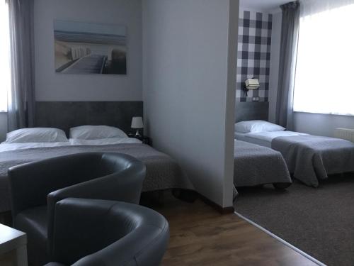 a hotel room with two beds and a chair at OW Delta in Rewal