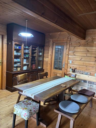 a dining room with a large wooden table and chairs at Based Inn Okayama Kurashiki in Okayama