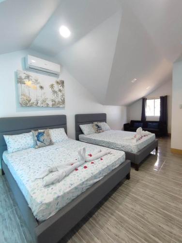 a bedroom with two beds with white pillows at Villa Loreta Beach Resort in Zambales