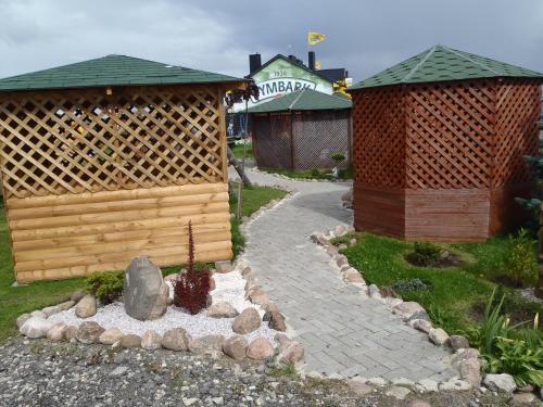 a garden with two huts and a fire place at Geltona in Šiauliai