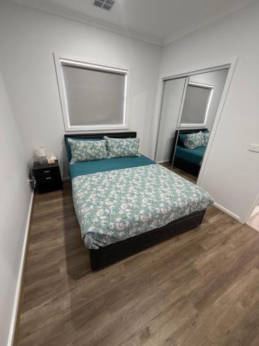 a small bedroom with a bed and two mirrors at Private Room in Rockbank in Rockbank