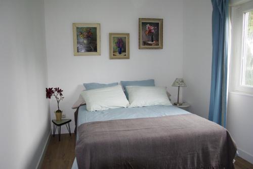 ein Schlafzimmer mit einem Bett mit zwei Bildern an der Wand in der Unterkunft Gîte De La Tulipe in Guéméné-Penfao