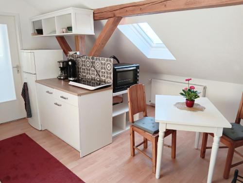 a kitchen with a desk and a table with a microwave at Gästezimmer in Diedorf