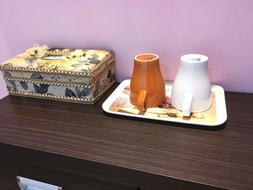 Una mesa con dos jarrones y una caja encima. en HFun Hotel, en Kaohsiung
