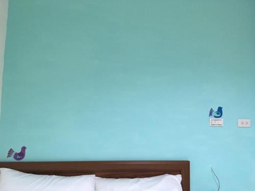 un mur bleu dans une chambre avec un lit dans l'établissement HFun Hotel, à Kaohsiung