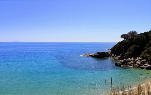 a view of a body of water with a beach at Appartamenti Maricampo - HelloElba in Marina di Campo