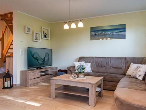 a living room with a couch and a tv at Ferienhaus Seegras in Groß Kirr