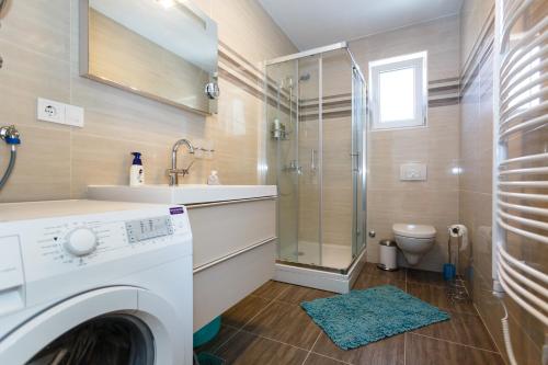 a bathroom with a washing machine and a shower at Apartment Marinela in Krk