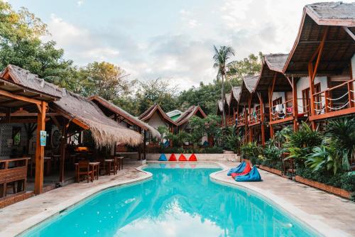 a resort swimming pool in front of houses at Voodoo Gili in Gili Trawangan