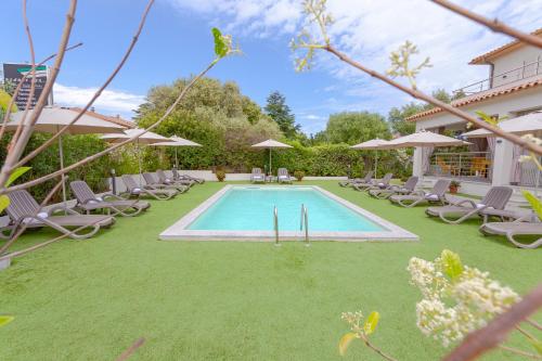 a swimming pool with lawn chairs and umbrellas at Le dune relax con cucina & piscina in San Teodoro