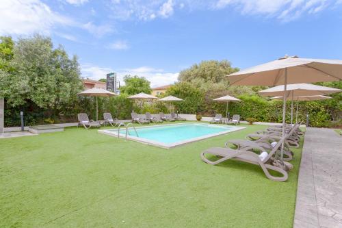 a swimming pool with chairs and umbrellas at Le dune relax con cucina & piscina in San Teodoro