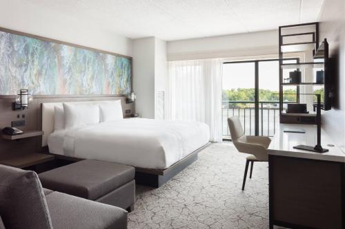a hotel room with a bed and a large window at Marriott Savannah Riverfront in Savannah
