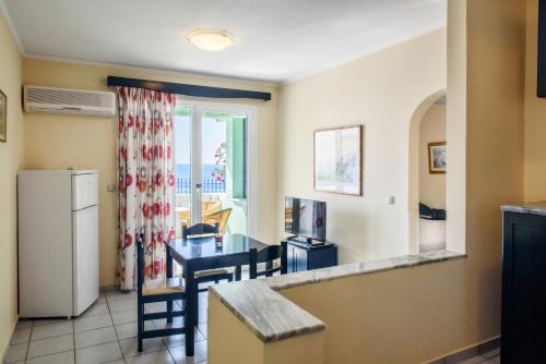 a kitchen and dining room with a table and a refrigerator at Sea Breeze Apartments Chios in Monolia