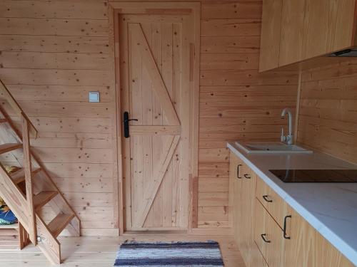 a kitchen with a door in a wooden wall at Zdalnie z Lasu - Siedlisko w Puszczy Białowieskiej in Narewka