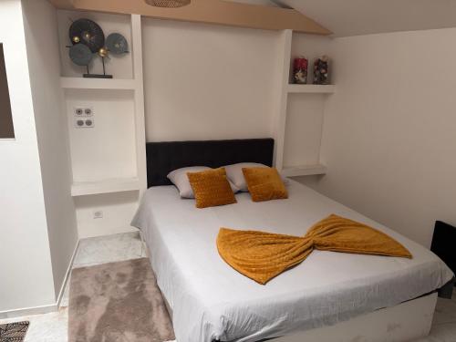 a bedroom with a bed with white sheets and orange pillows at Spa Jacuzzi Moon White in Vaudherland