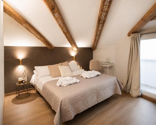 a bedroom with a large bed with two towels on it at Una Baita nel Centro di Pescara con Parcheggio Privato - Palazzo Carolina in Pescara