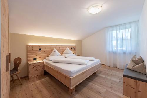 a bedroom with a large bed with a wooden headboard at Tirolerhof - panoramic apartments in Natz-Schabs