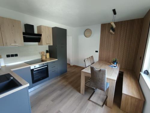 a kitchen with a wooden table and a dining room at Apartma Metka Bovec in Bovec