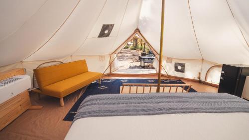 a bed and a chair in a tent at Chic Glamping Tent with Firepit in Branson