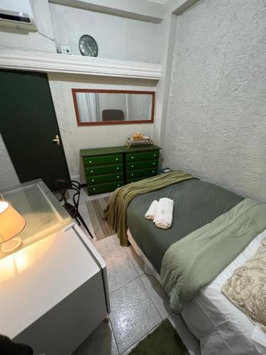 a bedroom with a bed and a table and a clock at BACKHOUSE Vieiralves - Manaus in Manaus