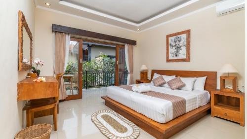 a bedroom with a bed and a balcony at Sriwedari 40 Ubud in Ubud
