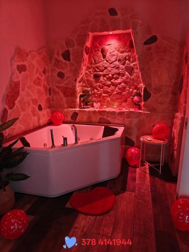 a bath tub in a room with a stone wall at Elysia Luxury Room con Jacuzzi - Centro Brindisi in Brindisi