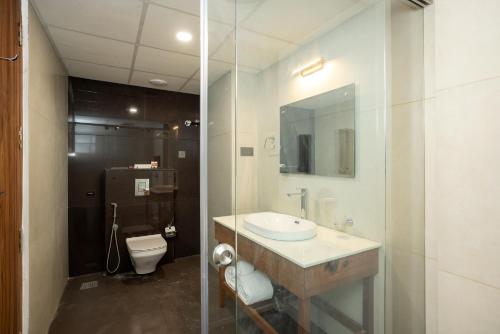 a bathroom with a sink and a toilet at Hotel Explora Calicut by Nova in Kozhikode