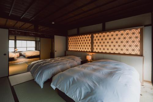 two beds in a bedroom with a window at RITA Okawa Hanzakai in Wakatsu