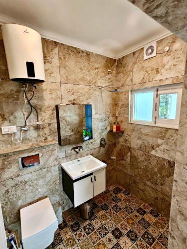 a bathroom with a sink and a mirror at Maskan by Rafiqi Estates - Deluxe 2BHK & Studio Apartments in Srinagar