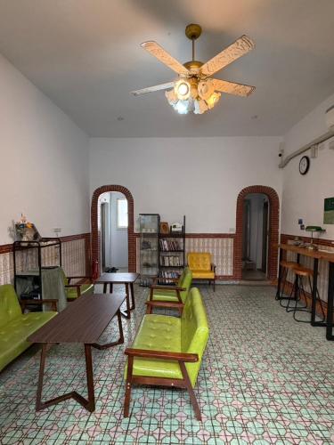 a living room with green chairs and a ceiling fan at 不倒翁輕旅可用優惠價預約機場碼頭接送 in Hsi-kuo-shan
