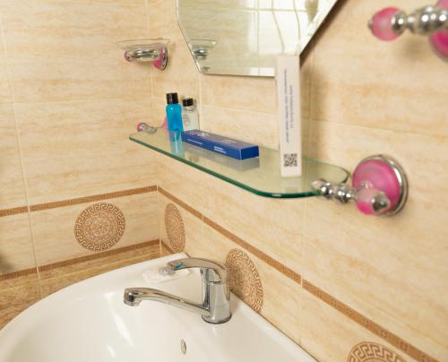 a bathroom with a sink and a mirror at Asson Hotel Termez in Termiz