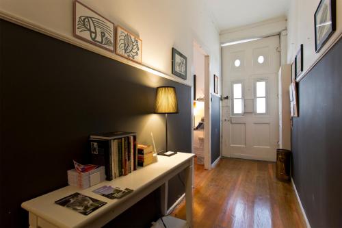 Habitación con escritorio con libros y lámpara. en Hostel Alegria, en Oporto